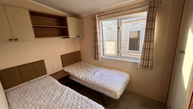 2 single beds in room with wardrobe