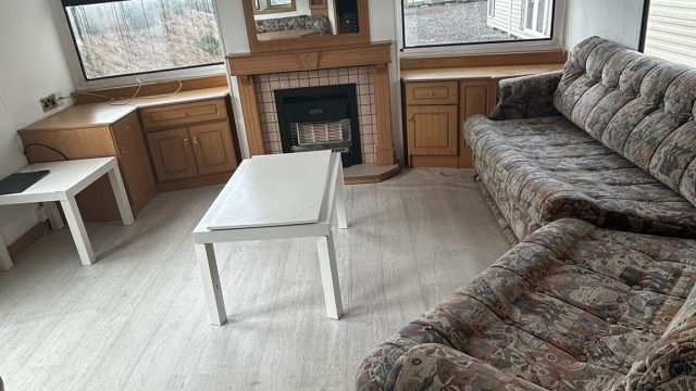 fireplace with mirror and two sofas in lounge Static Caravan.