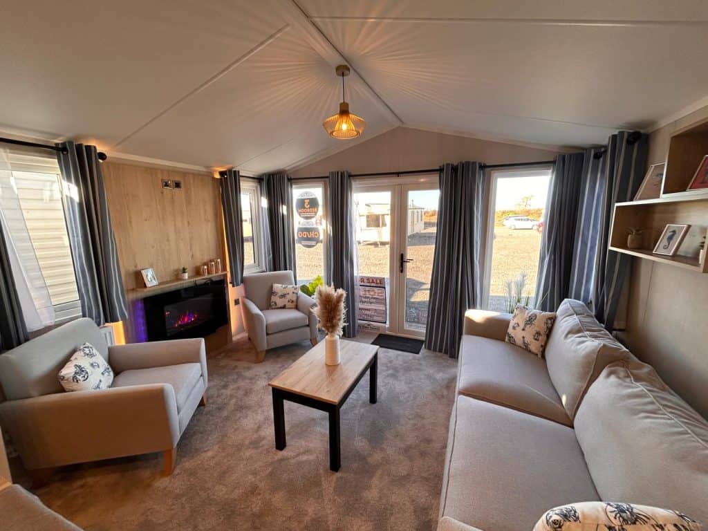 electric fire on wall with sofas and 2 armchairs. large patio doors