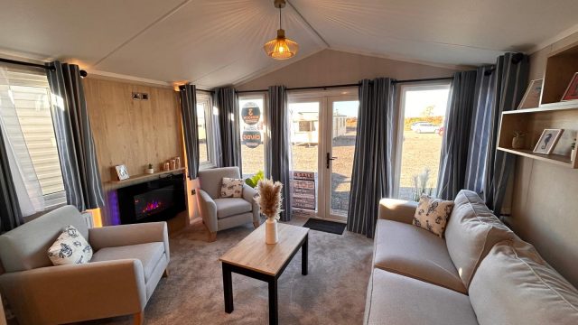 electric fire on wall with sofas and 2 armchairs. large patio doors