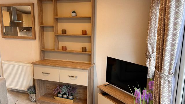 dresser with 2 drawers mirror on wall. TV on TV cabinet