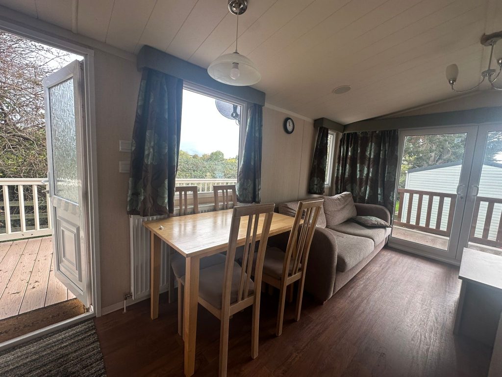 pine dining table and four chairs by window.