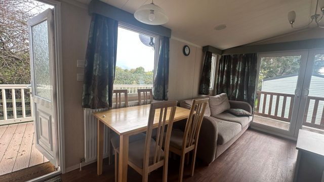 pine dining table and four chairs by window.