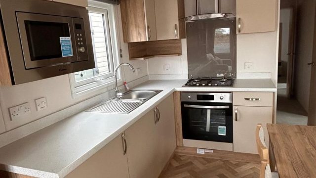 Kitchen with mircowave built in and gas cooker, herribone flooring