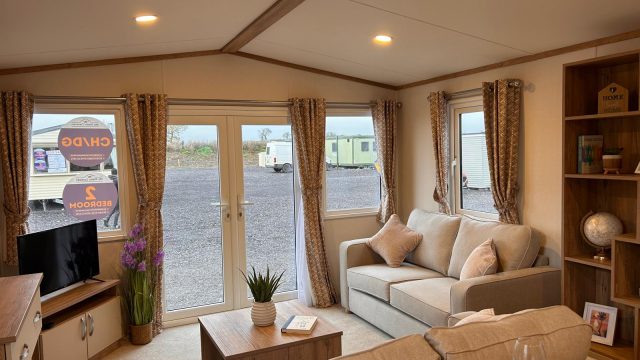 2 seater sofa with cushions. kitchen with cupboards