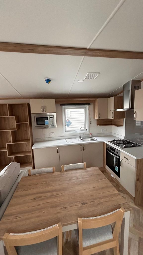 fitted kitchen with wooden table and four chairs