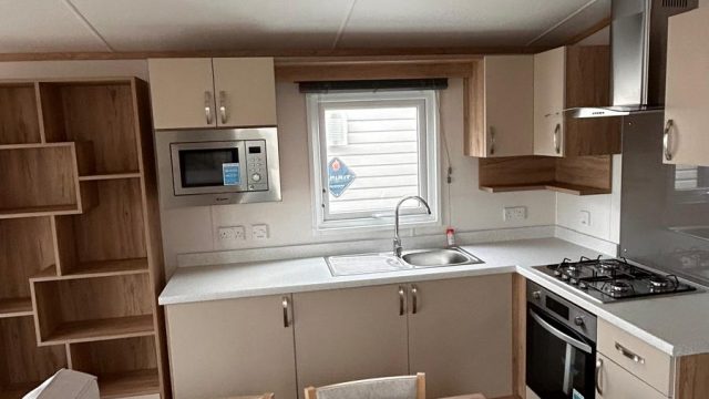 fitted kitchen with wooden table and four chairs