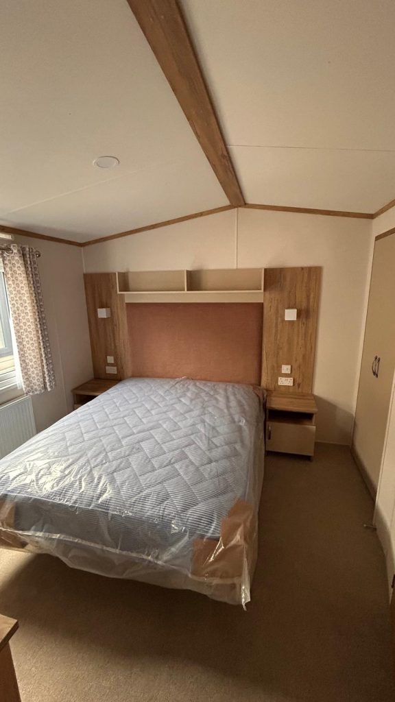 Double bed with shelving above bed and bedside tables