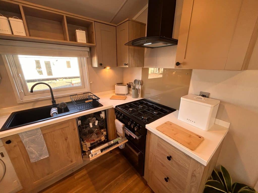 gas cooker with extractor hood. black sink with tap.