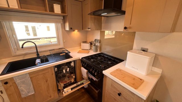 gas cooker with extractor hood. black sink with tap.
