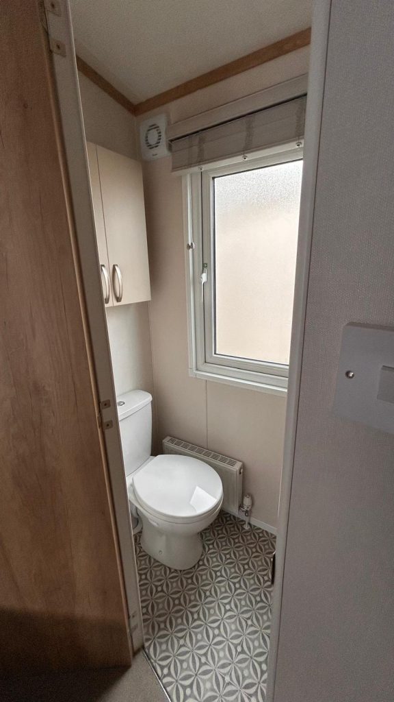 toilet with cupboard above