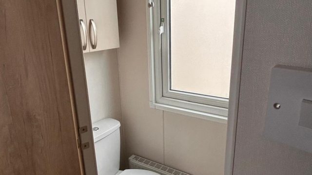 toilet with cupboard above