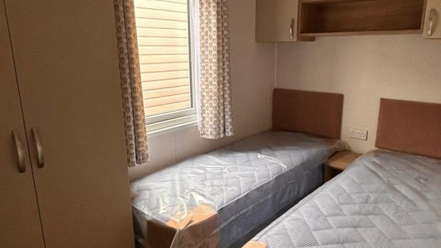 2 single beds in a room with wardrobe
