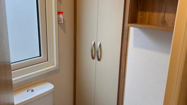toilet, shelving on wall and cupboard
