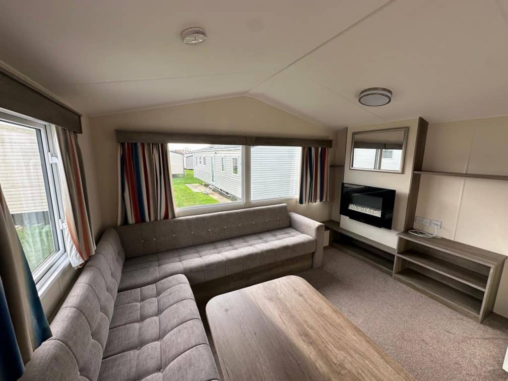 large corner fixed sofa, electric fire on wall with mirror above