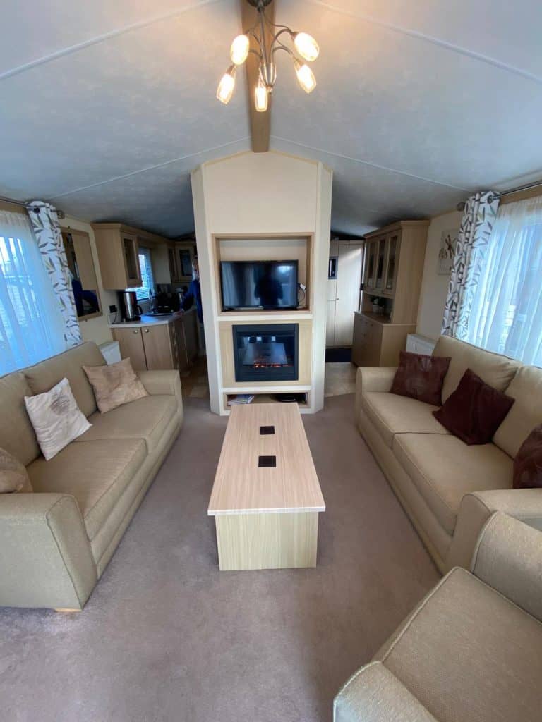 2 sofas with coffee table and electric fire and TV on wall