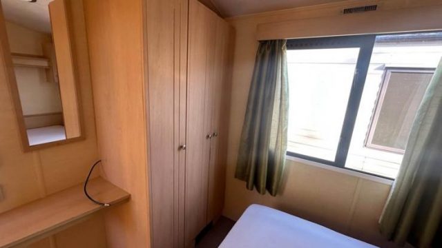wooden double wardrobe. window with green curtains