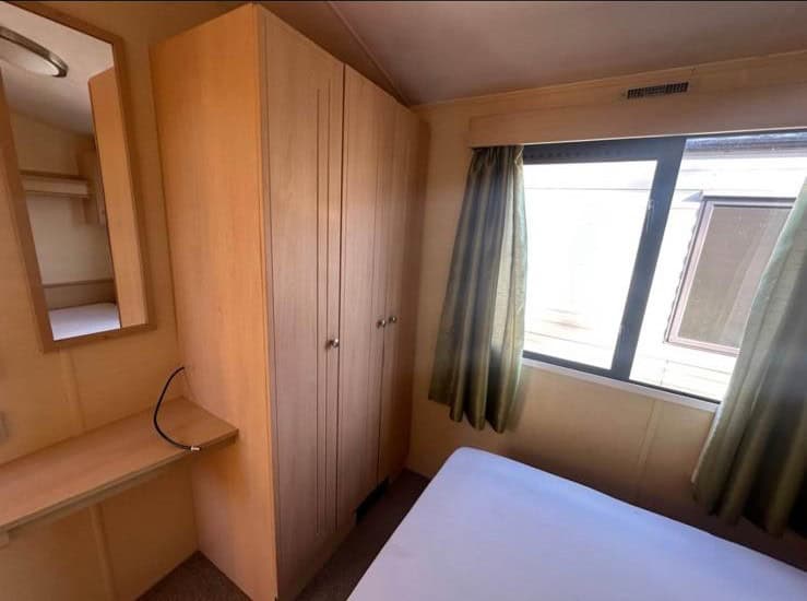 wooden double wardrobe. window with green curtains