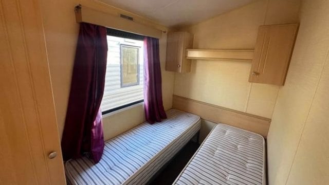 two single beds side by side with over head storage