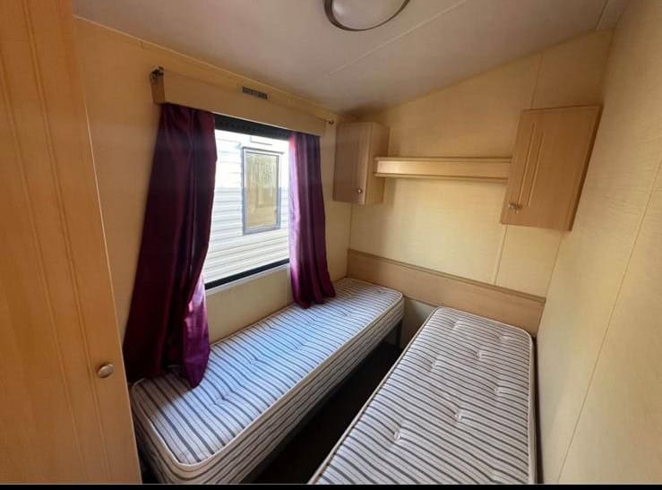 two single beds side by side with over head storage