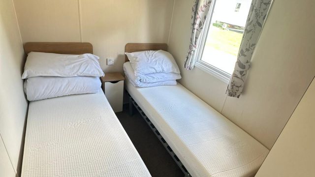 two single beds in room with side window