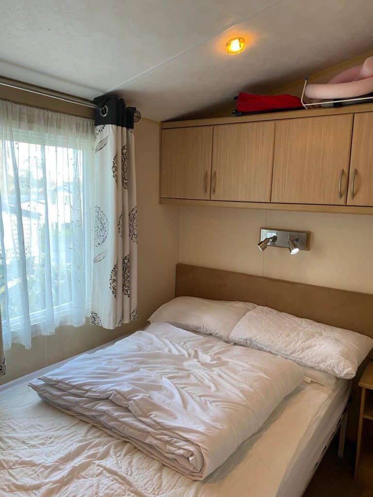 Double bed by window with over bed storage