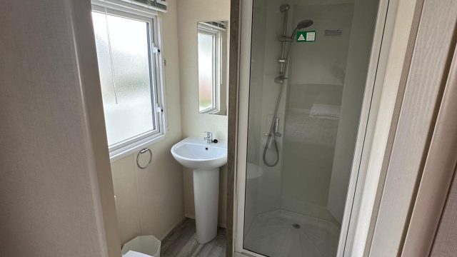shower cubicle with wash basin next to it.