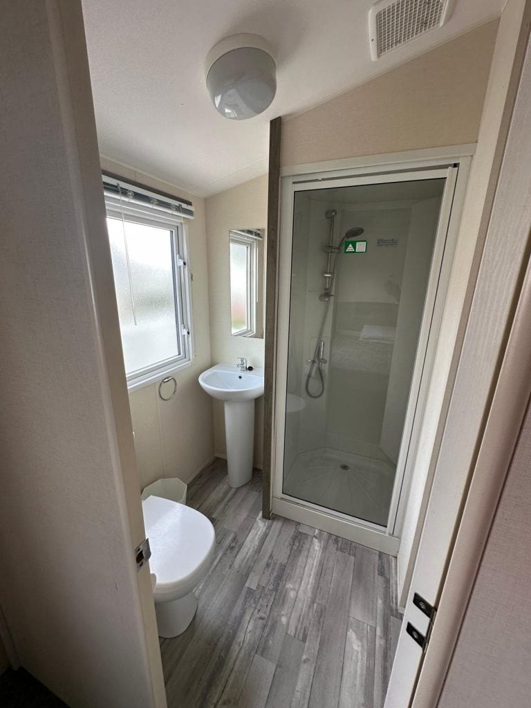 shower cubicle with wash basin next to it.