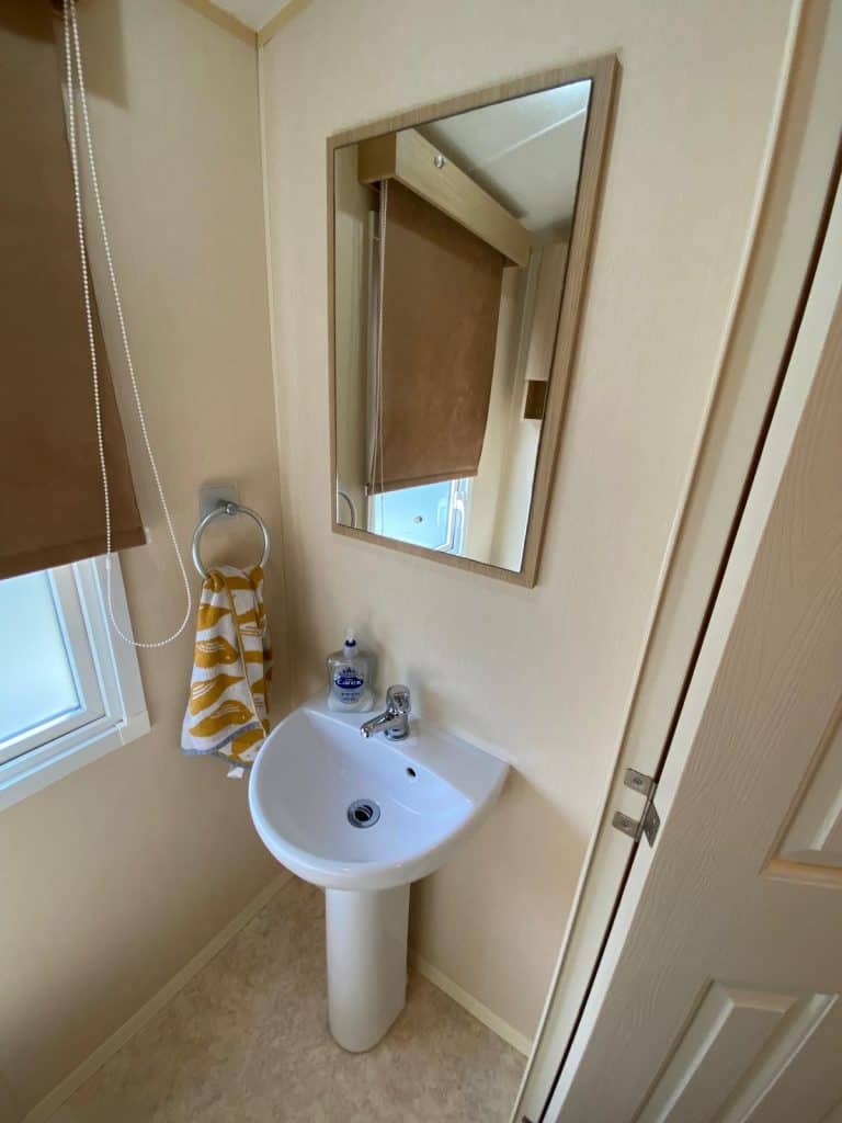 white hand basin with mirror on wall