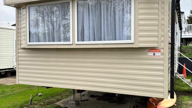 Cream static caravan on a holiday pitch.