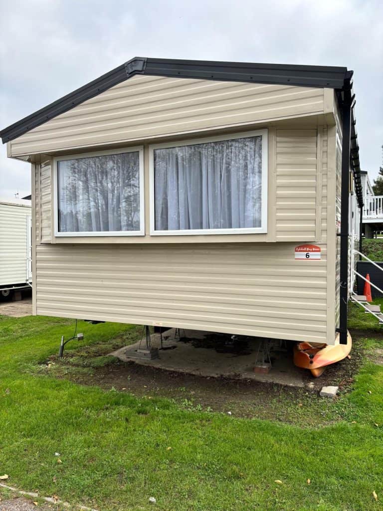 Cream static caravan on a holiday pitch.